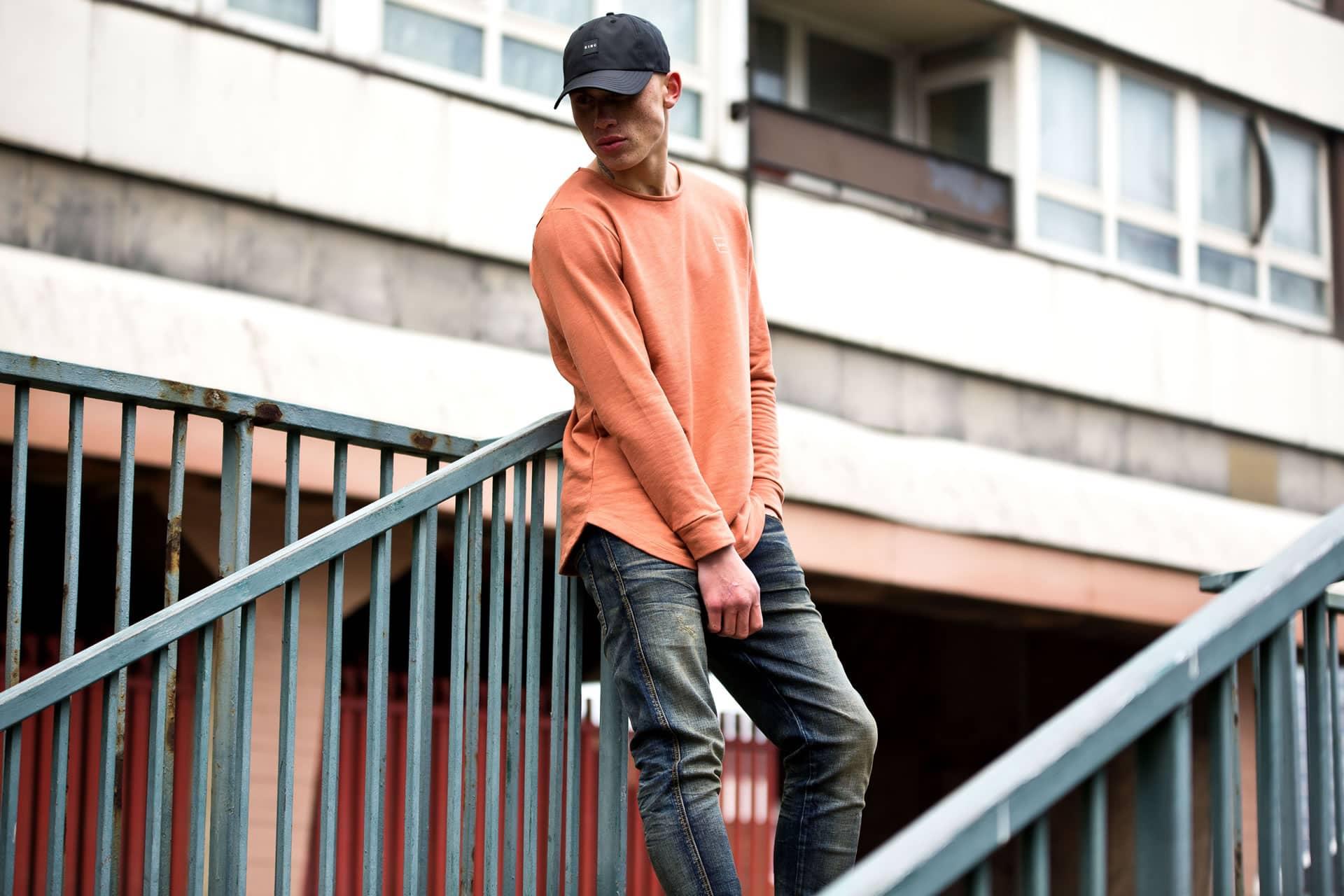Model wears curved peak cap, sweatshirt and jeans from King Apparel Autumn / Winter 2017 collection
