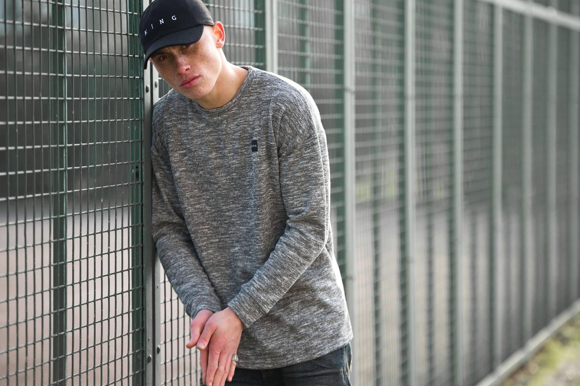 Model wears curved peak cap and knit sweatshirt from King Apparel Autumn / Winter 2017 collection