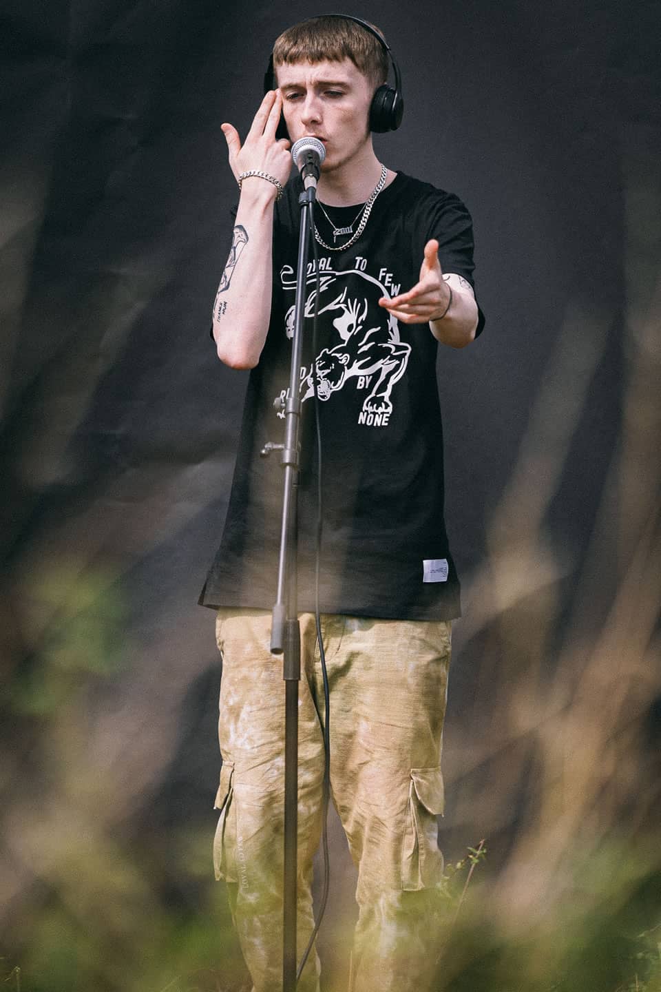 Hen$haw wears King Apparel Earlham Panther t-shirt in black and cargo pants in camo acid wash