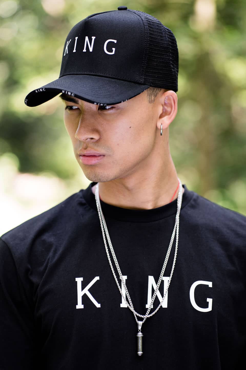 Model wears King Apparel Stepney mesh trucker cap and t-shirt in black