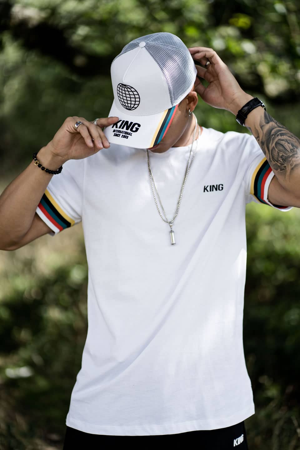 Model wears King Apparel Bethnal curved peak cap and t-shirt in white