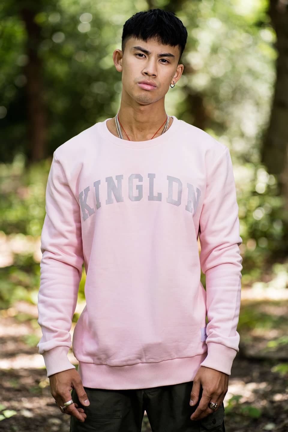 Model wears King Apparel Blackwall Varsity sweatshirt in blush pink