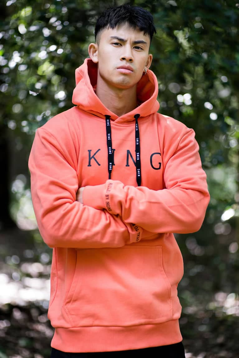 Model wears King Apparel Stepney hoodie in coral