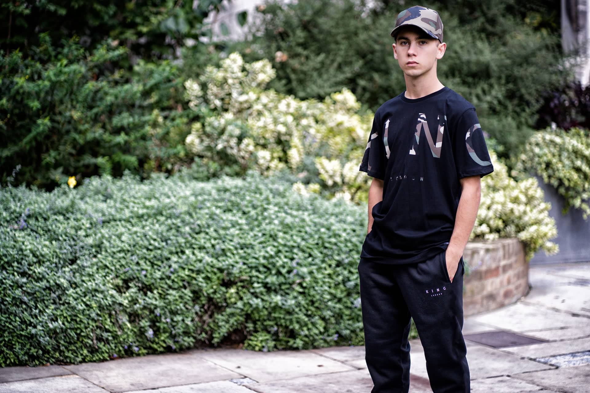 Tommy B wears King Apparel Leyton curved peak cap and t-shirt in black