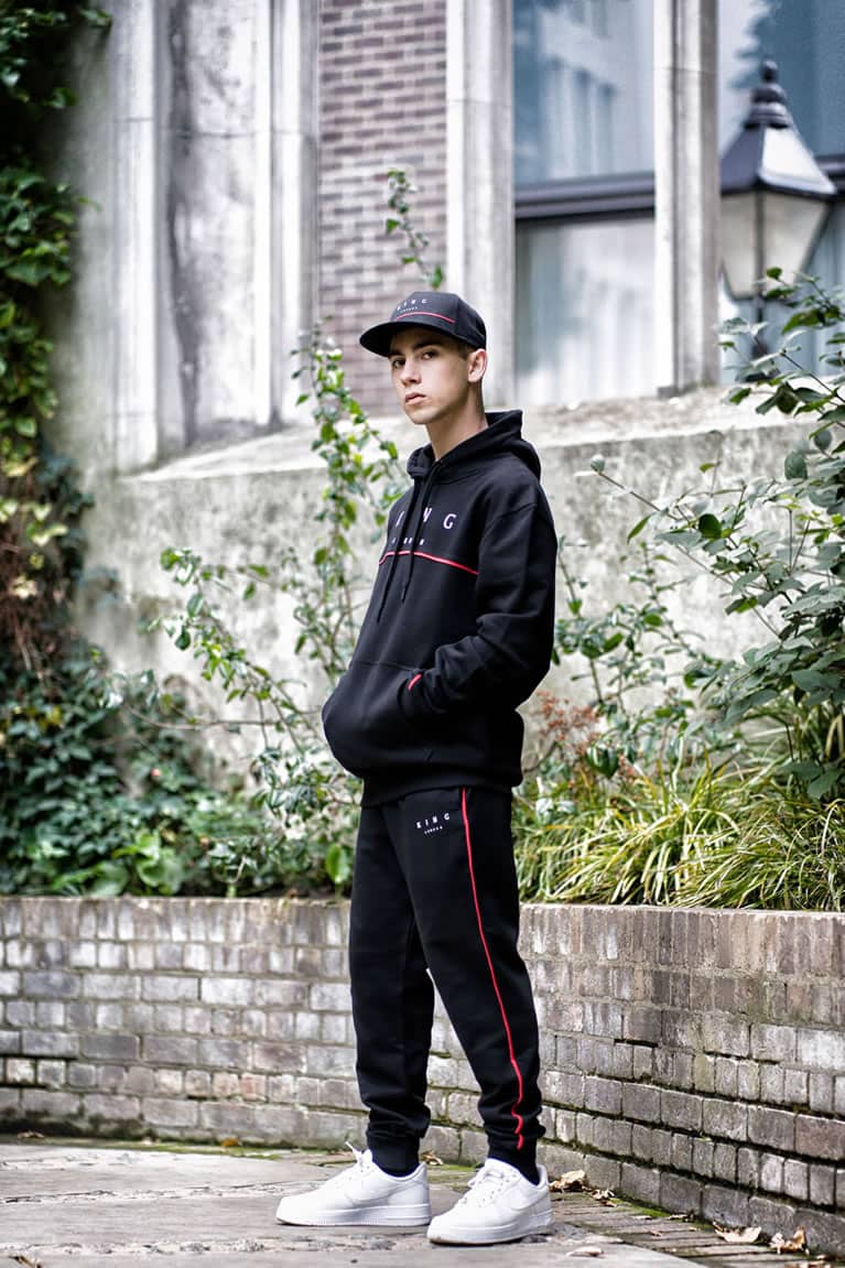 Tommy B wears King Apparel Tennyson snapback cap and tracksuit in black
