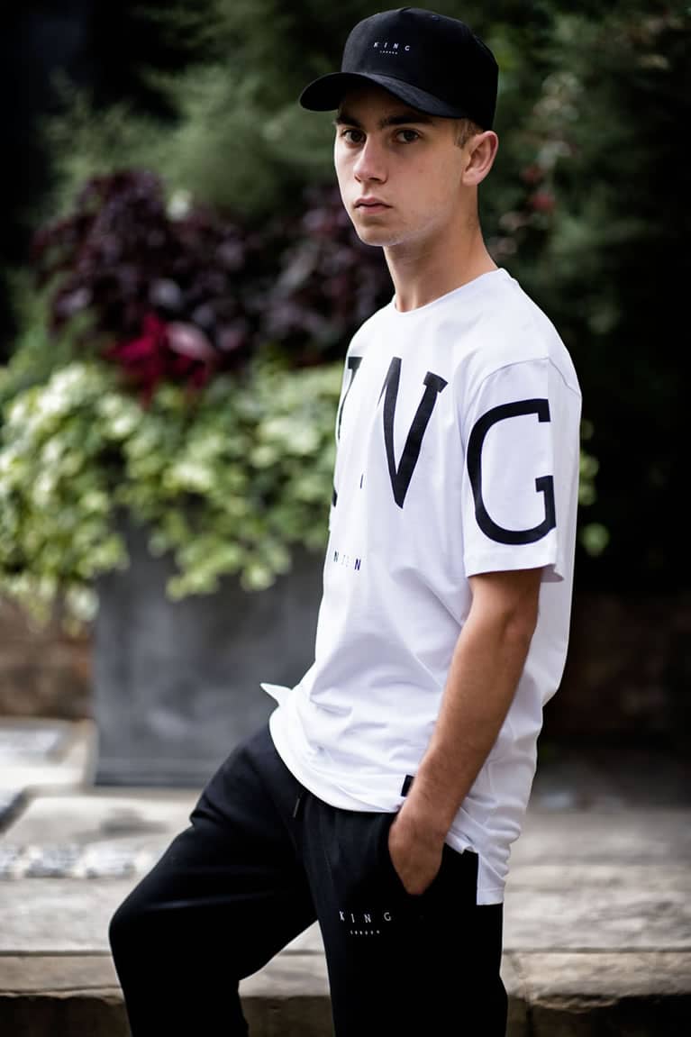 Tommy B wears King Apparel Leyton curved peak cap in black and t-shirt in white