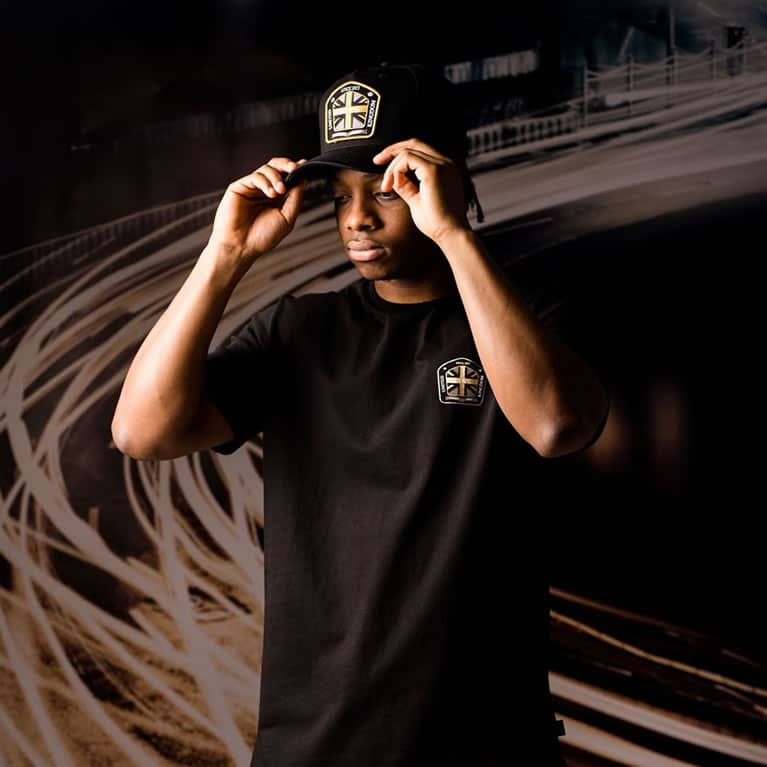 Poundz wears King Apparel Regal curved peak cap and t-shirt in black