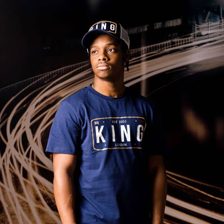 Poundz wears King Apparel Sovereign mesh trucker cap and t-shirt in ink blue