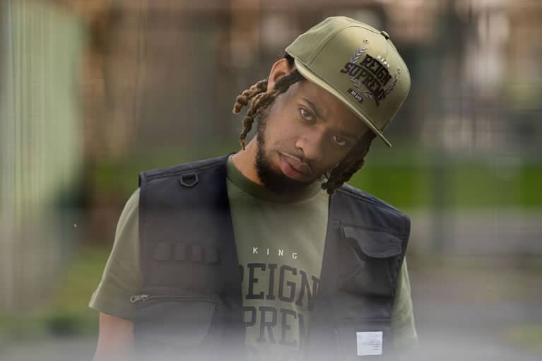 Bandanna wears King Apparel Earlham Tech snapback cap and t-shirt in fern green and tactical vest in black