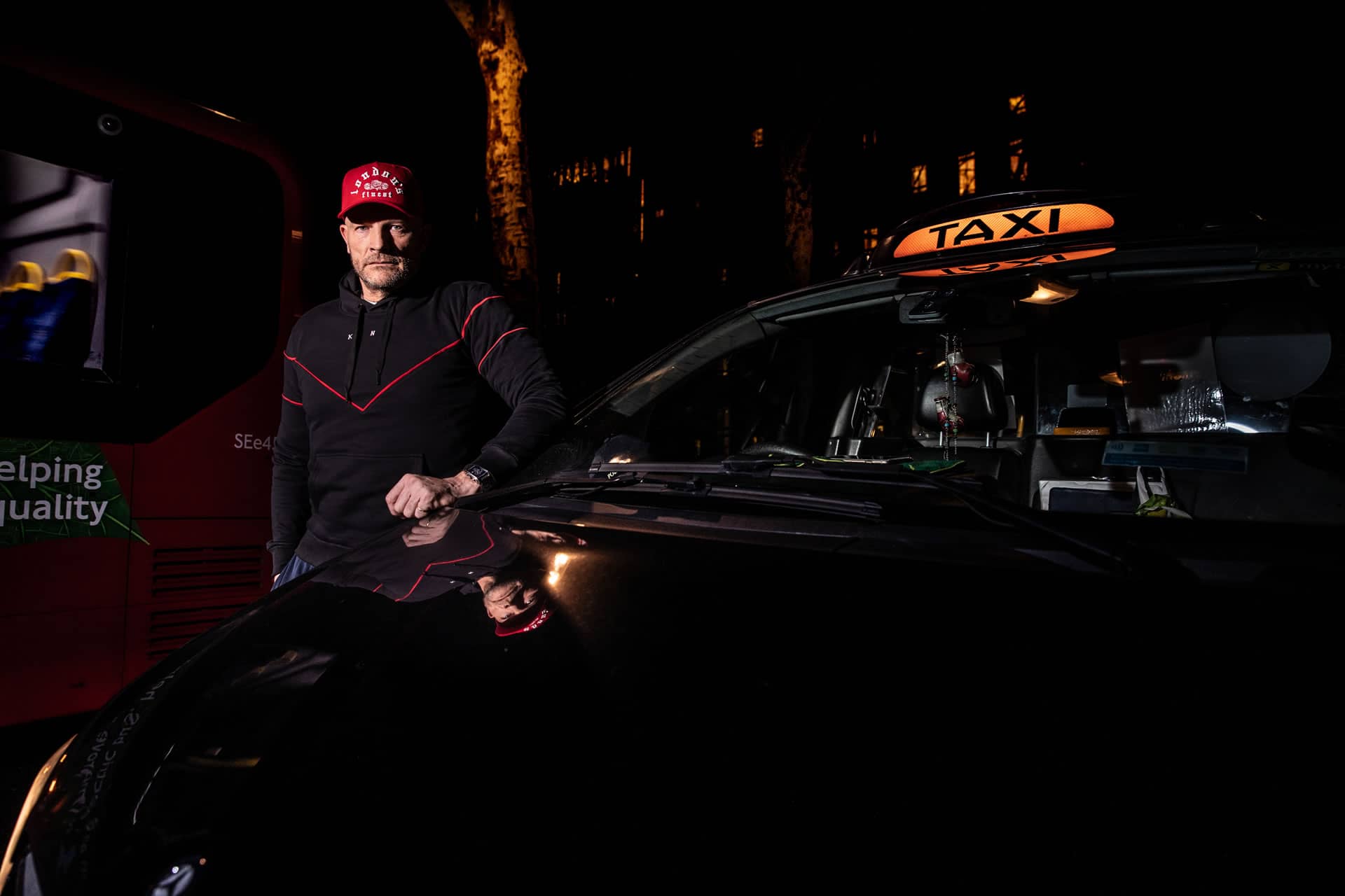 Cabbie wears King Apparel Whitechapel curved peak cap in crimson red and Tennyson tracksuit hoodie in black